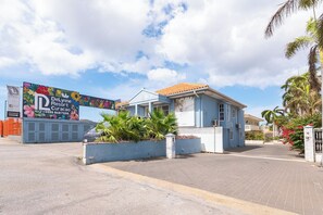 A building with a blue facade and a sign for DeLynne Resort. - Delynne Boutique Hotel (Willemstad)