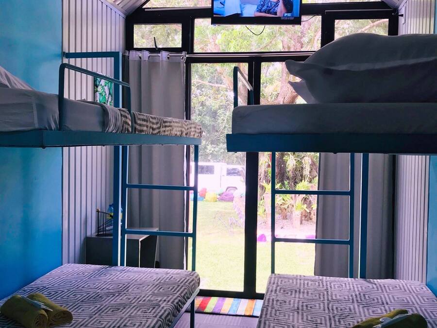 Habitación tipo dormitorio con literas, televisión y vista al exterior.