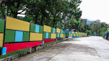 A concrete pathway lined with colorful corrugated metal fences.