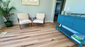 A room with two chairs, a blue cabinet, and a potted plant.