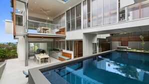 A modern two-story house with a large swimming pool, outdoor seating, and a balcony. - Seaview Tce - Spectacular Home with Stunning Ocean and Headland Views (SUNSHINE BEACH)