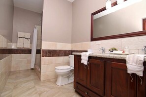 Een bad/douchecombinatie, een haardroger, handdoeken, zeep