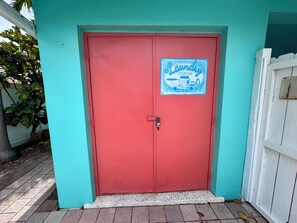 A red door with a sign that reads 'The Laundry Room' and 'Loads of Fun'. - Stay Near Deerfield Beach Pier, Enjoy Our Cozy 1-bedroom Apartment (Deerfield Beach)