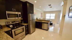 A modern kitchen with stainless steel appliances, granite countertops, and a clean, tiled floor. - Stay Near Deerfield Beach Pier, Enjoy Our Cozy 1-bedroom Apartment (Deerfield Beach)