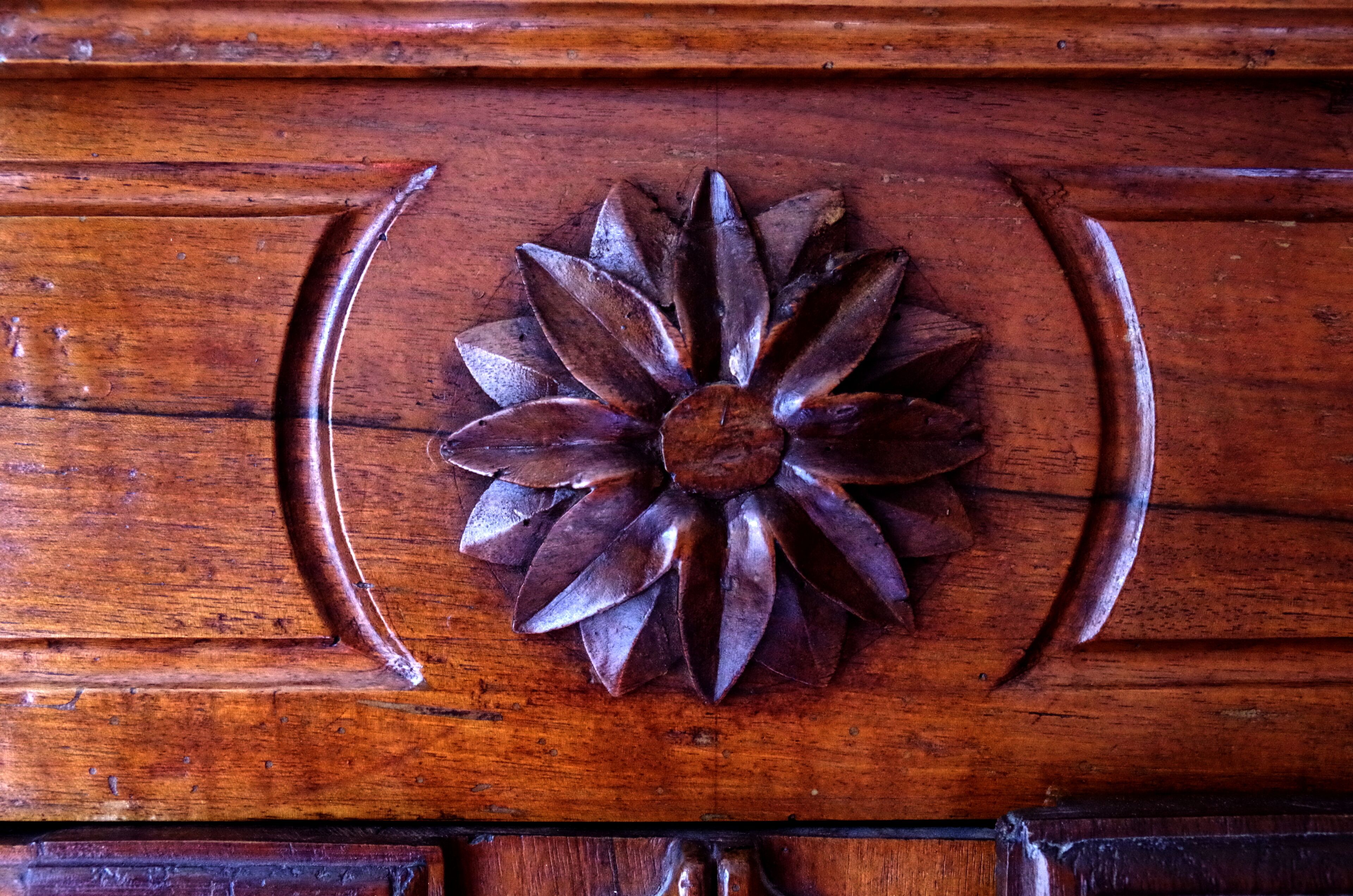 A wooden surface with a carved floral design.
