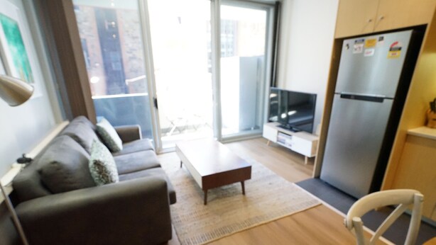 Een moderne woonkamer met een bank, een salontafel en een televisie.