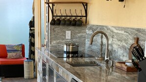 Een moderne keuken met een marmeren aanrechtblad, roestvrijstalen apparatuur en een geïntegreerde vaatwasser.