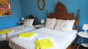Una habitación de hotel con dos camas, un cabecero de madera, un espejo y un cartel en la pared.