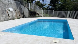A rectangular swimming pool with clear blue water, surrounded by light-colored tiled flooring. - Exceptional Seaview - All The Comforts You Need (Schoelcher)