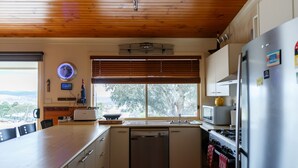 A kitchen with a wooden ceiling, a dishwasher, a stove, and a refrigerator. - Misty Mountain -  September Special Now Available (Jindabyne)