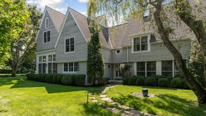 A two-story house with a well-maintained lawn and a stone pathway leading to the front door. - Stunning House: Tennis & Pool in Southampton Estate section (Southampton)