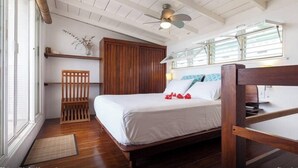 A bedroom with a wooden bed, a ceiling fan, and a window with blinds. - Plantation House - Ocean view - Family and pet friendly (Playa del Carmen)
