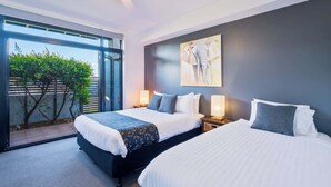 A modern hotel room with two beds, a large window, and a ceiling fan. - Unit 3 - Modern 2BR Apartment on Huskisson Main Street By Nautilus Apartments Je (Huskisson)