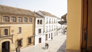 A street view with buildings featuring arched windows and balconies, a clear sky, and a few pedestrians. - Beautiful And Central House For Up To 8 Guests (Cordoba)