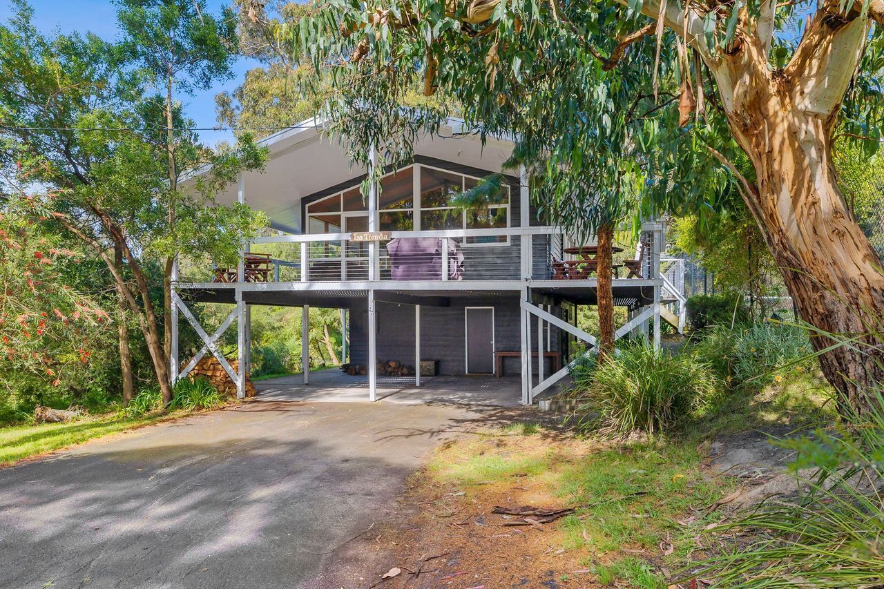A two-story house with a covered outdoor area and a staircase leading to the upper level.