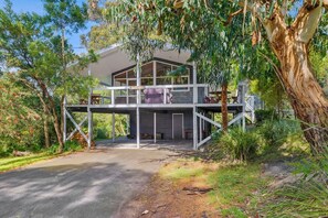 A two-story house with a covered outdoor area and a staircase leading to the upper level. - La Tienda (Lorne)