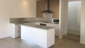 Una cocina moderna con una isla central, electrodomésticos integrados y un diseño elegante.