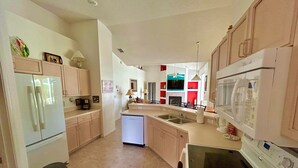 A kitchen with a refrigerator, microwave, sink, and stove. - Stunning Lakeview Villa (Davenport)