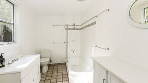Een badkamer met toilet, wastafel en douche.
