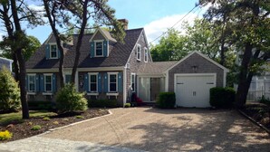 A two-story house with a front driveway, a garage, and a well-maintained lawn. - SHORT WALK TO BEACH Central A/C (Dennis Port)