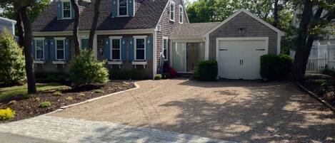 A two-story house with a front driveway, a garage, and a well-maintained lawn.