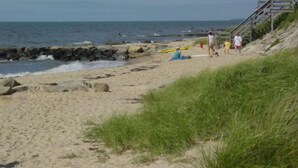A beach with a wooden staircase leading down to the water, rocky shoreline, and people walking. - SHORT WALK TO BEACH Central A/C (Dennis Port)