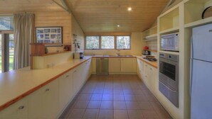 Cocina compacta con isla central, electrodomésticos integrados y vistas a través de las ventanas.