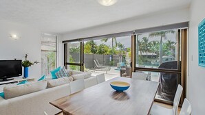 Un salon moderne avec un canapé, une table basse et un téléviseur.