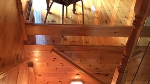 Un escalier en bois avec une rampe en verre, menant à un niveau supérieur.