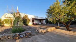 A building with a stone pathway leading to a bicycle parked in front. - villa 10 min from Gallipoli | entire structure | swimming pool and large garden (Sannicola)