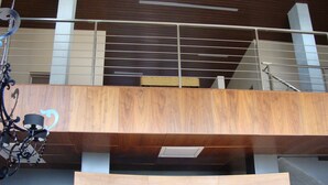 Un taulell de recepció modern amb acabat de fusta i baranes metàl·liques.