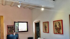 A room with a wooden ceiling, a television, and three framed artworks on the wall. - Silvia A/B - SILVIA B (Capoliveri)
