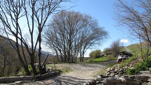 Ein Kiesweg, der durch einen Park mit Steinmauern und Bänken führt.