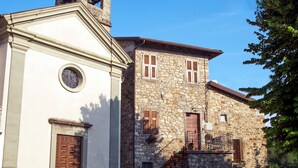 A historic building with a white facade and a stone structure with wooden shutters. - Historic village house with private pool, gardens & outdoor dining, near Bagnone (Bagnone Massa Carrara)