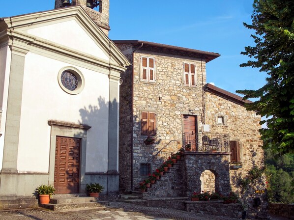 A historic building with a white facade and a stone structure with wooden shutters. - Historic village house with private pool, gardens & outdoor dining, near Bagnone (Bagnone Massa Carrara)