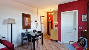 A compact living space with a dining area, kitchenette, and a red accent wall.