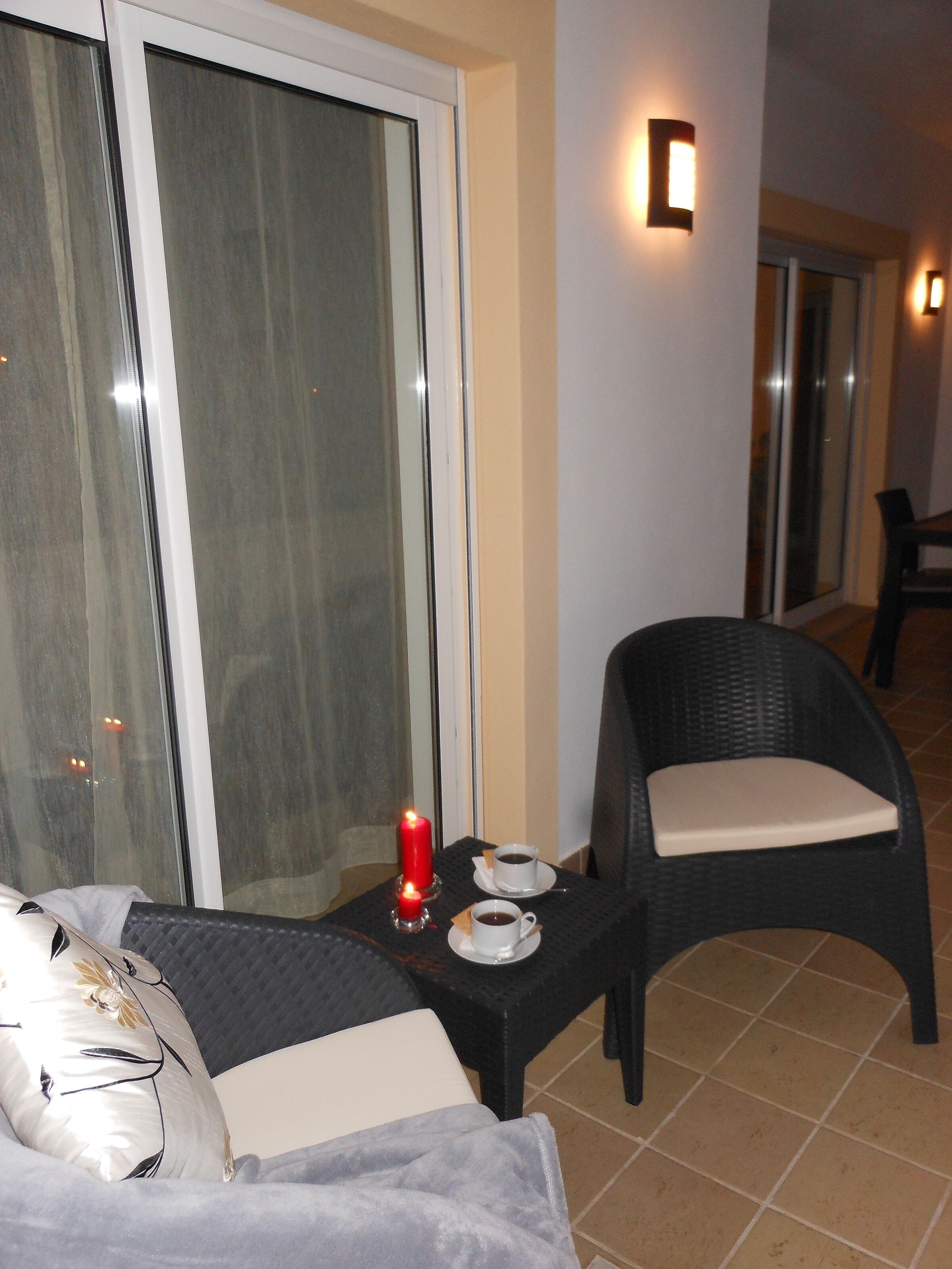 Une pièce confortable avec un lit, une petite table sur laquelle est posée une bougie et une chaise.