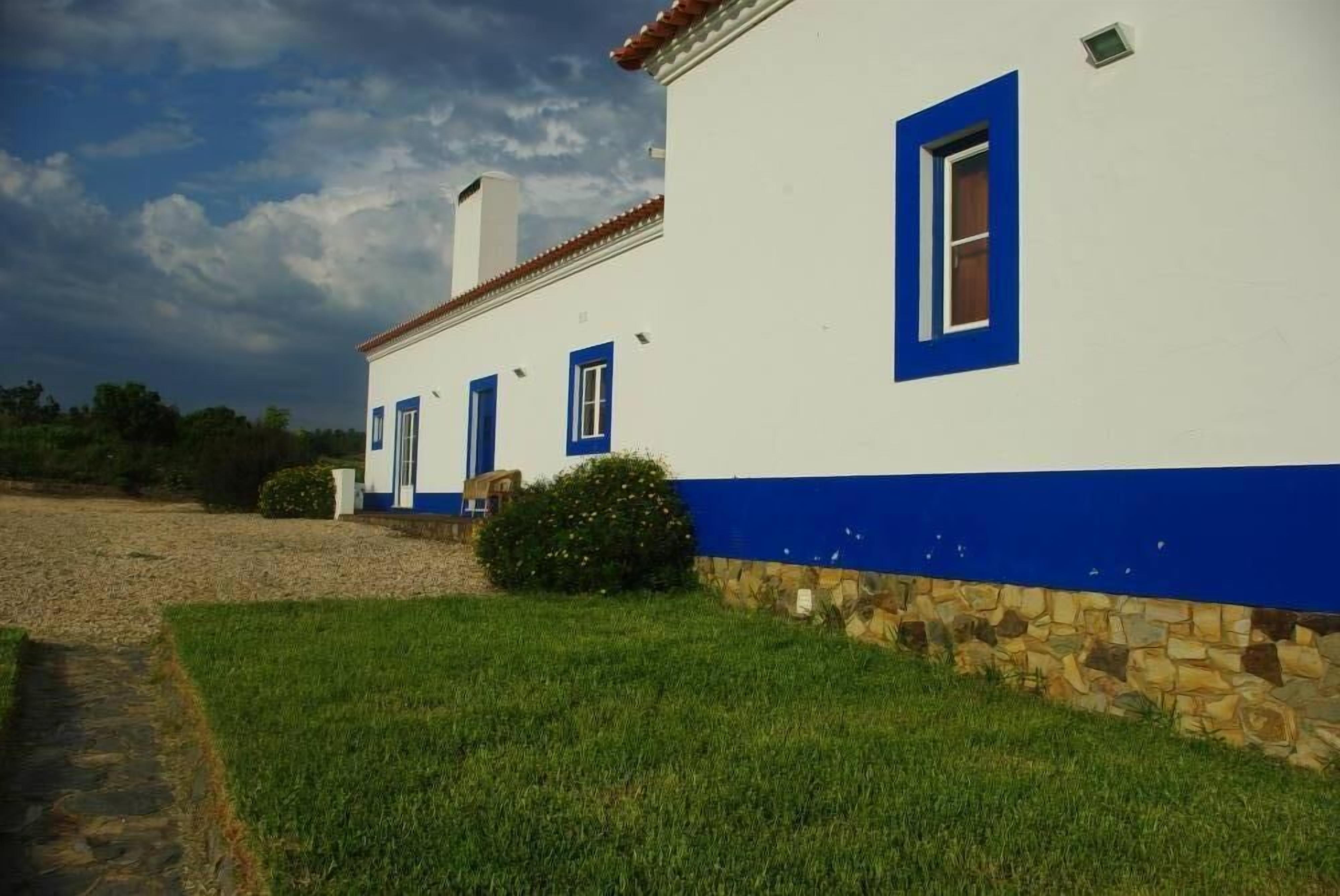 Un edificio blanco con detalles azules y cimientos de piedra.