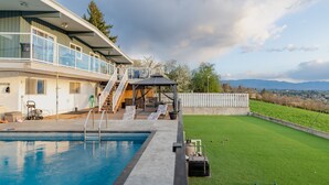 A modern house with a swimming pool, a covered patio, and a well-maintained lawn. - Perfect retreat * LEGAL BNB *  4 rooms on site. Group bookings available. (Kelowna)