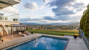 A swimming pool with a view of a residential area and mountains in the background. - Perfect retreat * LEGAL BNB *  4 rooms on site. Group bookings available. (Kelowna)