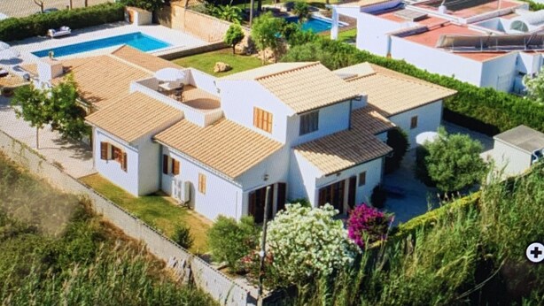 Un área residencial costera con casas, una piscina y vista al mar.