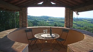 A circular outdoor seating area with a table and chairs, overlooking a scenic landscape.