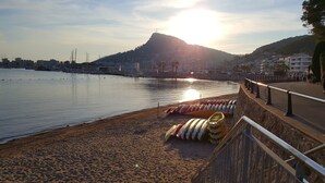Una playa con kayaks y una montaña al fondo.