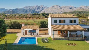 A two-story house with a swimming pool, outdoor seating, and a view of mountains. - Ca Na Volantina - Great family villa close to Puerto Pollensa (Port de Pollença)