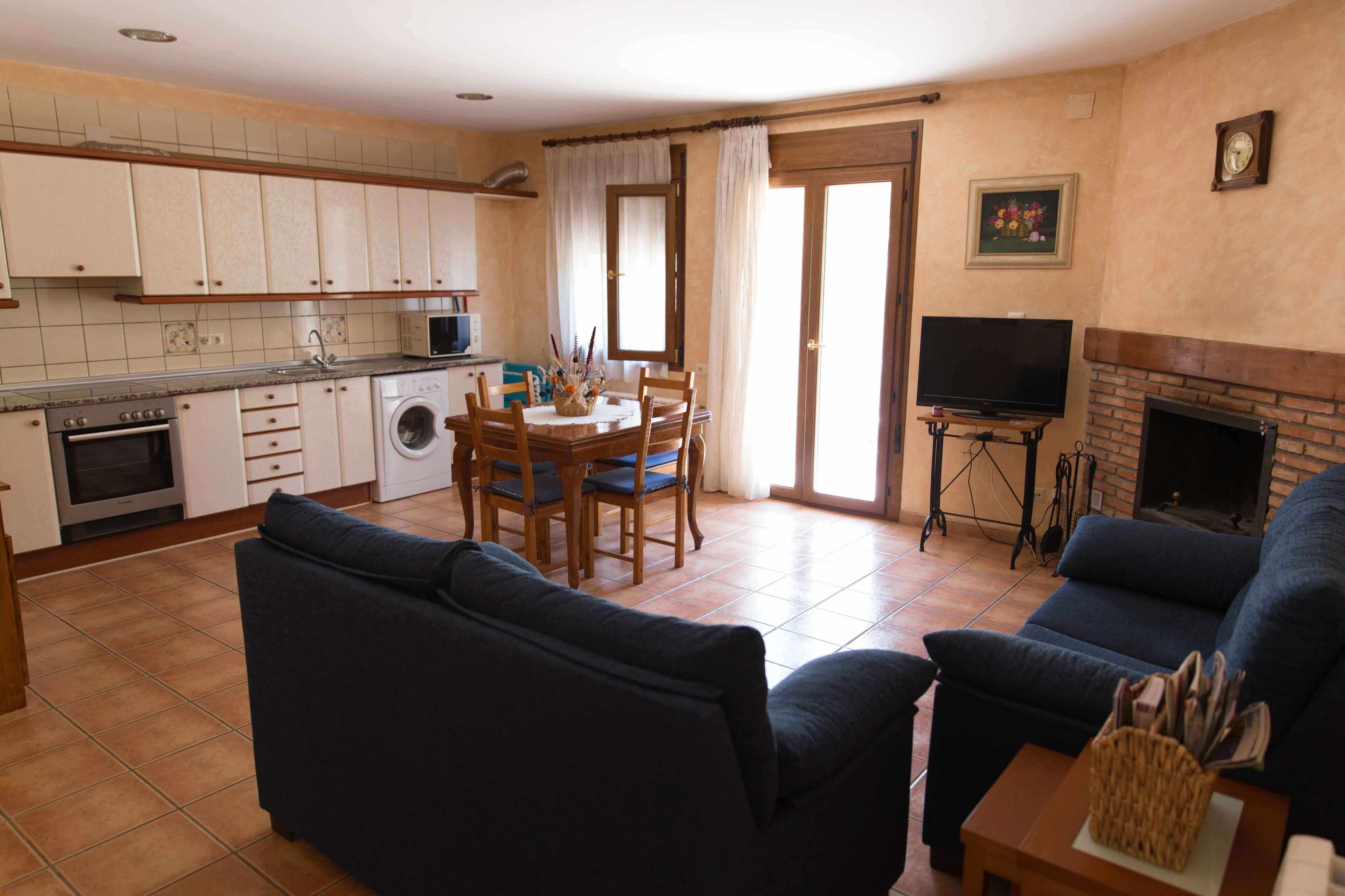 Un espacio habitable compacto con cocina, comedor y zona de estar.