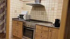 A compact kitchen with a microwave, stove, and oven. - Casa Lola Beceite Apartments, mountain views and petfriendly (Beceite)