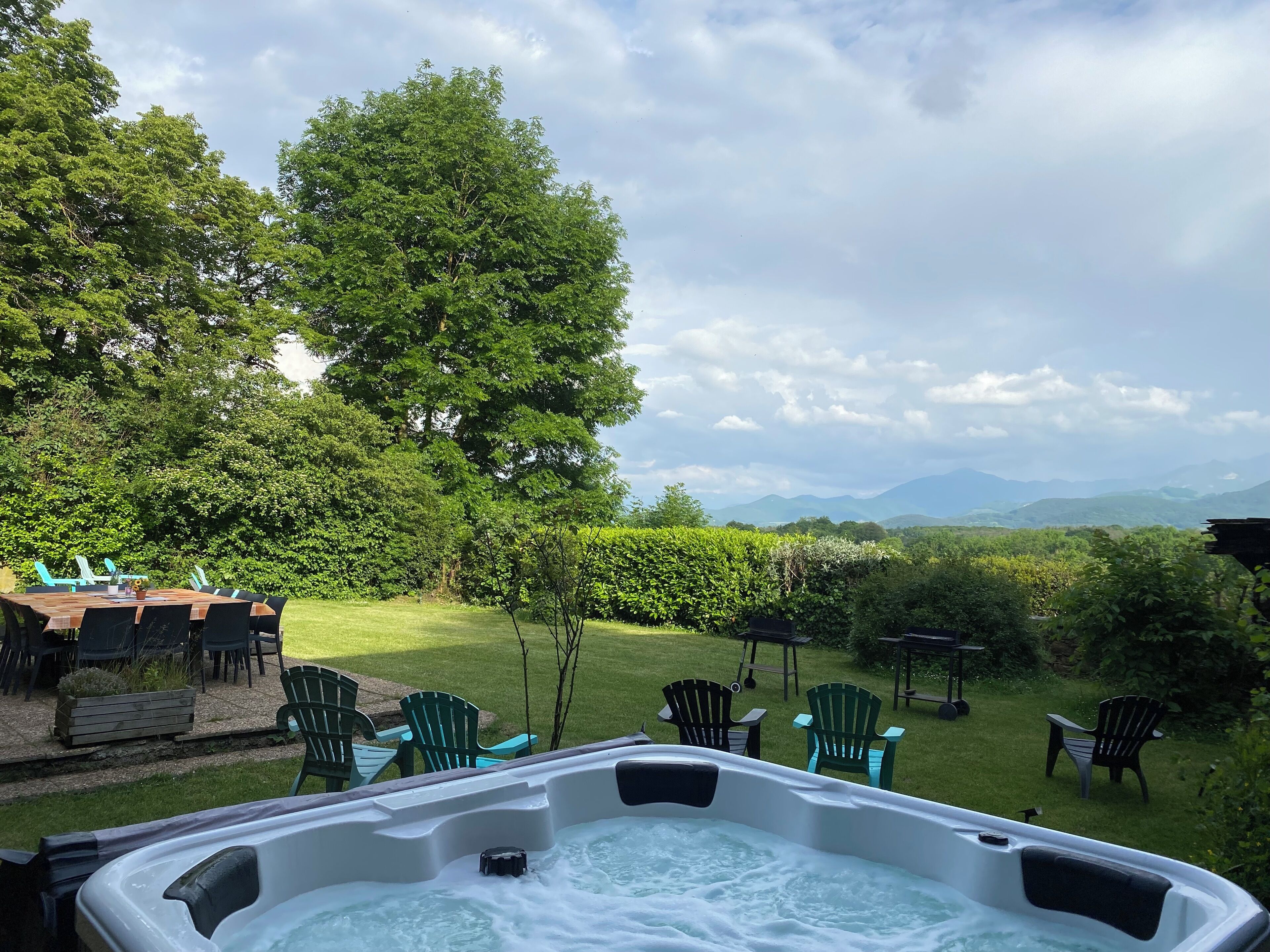 A hot tub with a view of a grassy area and trees.