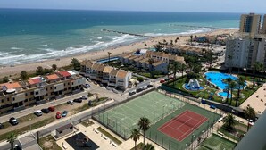 Zona residencial costera con playa, piscina y cancha de baloncesto.