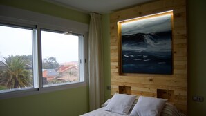 Un dormitorio con cama, ventana y un cuadro en la pared.