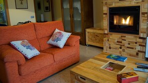 Una sala de estar con un sofá, una mesa de centro de madera, una chimenea y un armario.